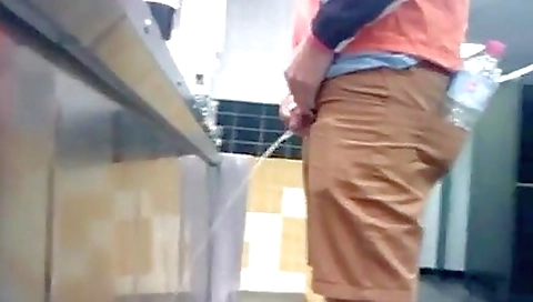 Amateur in the urinal room is having some fun taking off his clothes